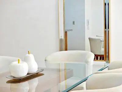 a living room with a glass table and white chairs at Acogedor y Familiar in Colorado