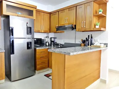 a kitchen with wooden cabinets and a stainless steel refrigerator at Acogedor y Familiar in Colorado