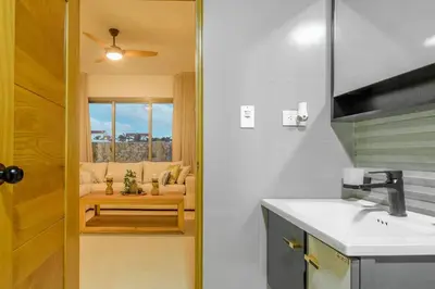 a kitchen with a sink and a living room at Villa Privada + Piscina | Playa & Golf in Punta Cana