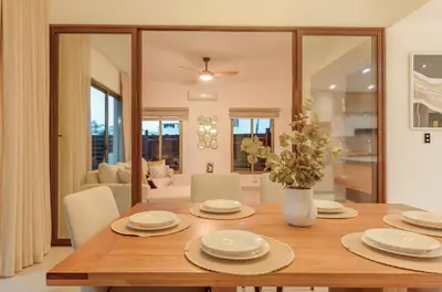 a dining room table with a vase of flowers at Villa Privada + Piscina | Playa & Golf in Punta Cana