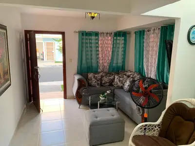 a living room with a couch and a chair at Seaside Elegance in Baní