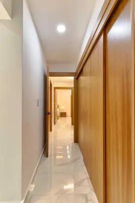 a corridor with wooden doors and a hallway with white tiles at Lovely 3 Bedroom Apartment, Pool,Gym,2parking S in Santo Domingo