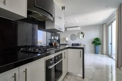 a kitchen with white cabinets and a stove top oven at Lovely 3 Bedroom Apartment, Pool,Gym,2parking S in Santo Domingo