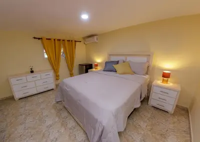 a bedroom with a white bed and two night stands at Hotel la Saladilla Beach Club in Santa Cruz de Barahona