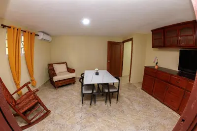 a living room with a table and a chair at Hotel la Saladilla Beach Club in Santa Cruz de Barahona