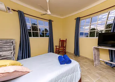 a bedroom with a bed with blue slippers on it at Hotel la Saladilla Beach Club in Santa Cruz de Barahona