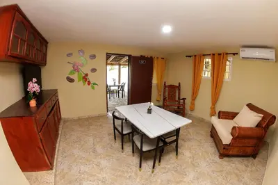 a living room with a table and chairs and a kitchen at Hotel la Saladilla Beach Club in Santa Cruz de Barahona