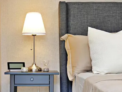 a bed with a lamp on a nightstand next to a table with a laptop at Mini Hogar 4 in Colorado