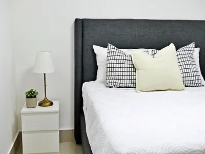 a bedroom with a bed with a black headboard and a lamp at Mini Hogar 3 in Colorado