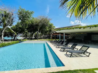 a swimming pool with lounge chairs next to a building at Marien Residences 222 Gardenview Condo in Puerto Plata