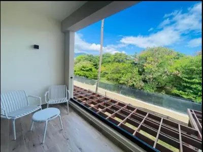 a balcony with two chairs and a large window at Marien Residences 222 Gardenview Condo in Puerto Plata