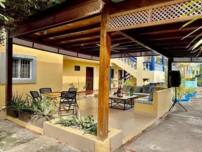 a patio with a wooden pergola with a table and chairs at Luperon Cerca del Mar in Colorado