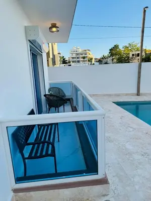 a balcony with a chair and a swimming pool at Modern Apartment in Bayahibe in Bayahibe