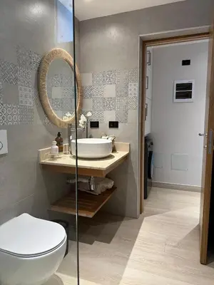 a bathroom with a toilet and a sink and a mirror at Garden Breeze Ghibli-Pool View in La Laguna