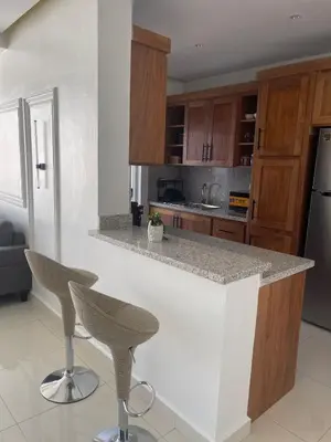 a kitchen with a counter and two bar stools at Sunset Residences 3BR, Pool & Beach Cosita Rica in Puerto Plata