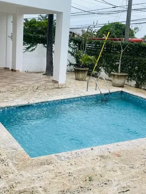 a swimming pool with blue water in a yard at Oasis Residences, Modern 3BR Apartment with Pool in San Felipe de Puerto Plata