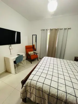 a bedroom with a bed and a desk and a chair at Oasis Residences, Modern 3BR Apartment with Pool in San Felipe de Puerto Plata