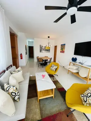 a living room with white furniture and a flat screen tv at Oasis Residences, Modern 3BR Apartment with Pool in San Felipe de Puerto Plata
