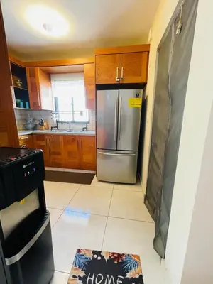 a kitchen with a stainless steel refrigerator and wooden cabinets at Modern 3BR with private pool near the beach in Puerto Plata