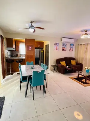 a kitchen and living room with a table and chairs at Modern 3BR with private pool near the beach in Puerto Plata