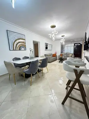 a dining room and living room with a table and chairs at Modern and fully equipped house in Samaná in Santa Bárbara de Samaná