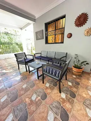 a patio with chairs and tables on a tile floor at Modern and fully equipped house in Samaná in Santa Bárbara de Samaná