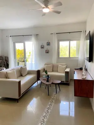 a living room with a couch and a table at Modern 2BR Condo Near the Beach Juan Dolio in Villas del Mar