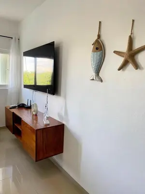 a room with a desk and a television and a starfish at Modern 2BR Condo Near the Beach Juan Dolio in Villas del Mar