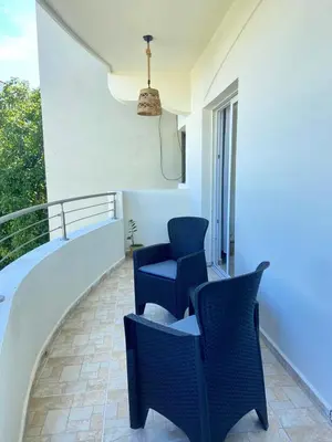 a balcony with two chairs and a railing at Modern 2BR Condo Near the Beach Juan Dolio in Villas del Mar