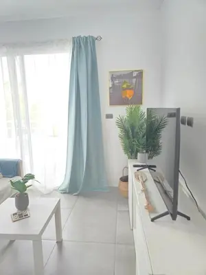 a living room with a tv on a dresser at Estrella Condos 8min walk to the beach Studio 201A in La Laguna