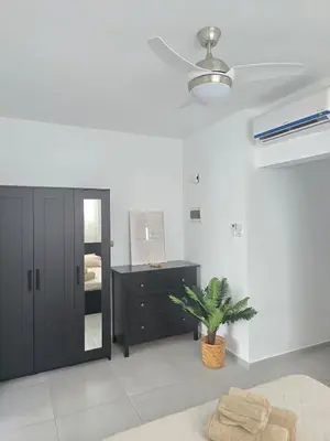 a bedroom with a black cabinet and a potted plant at Estrella Condos 8min walk to the beach Studio 201A in La Laguna
