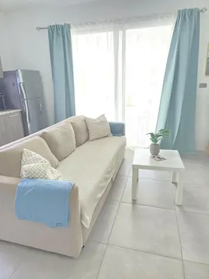 a living room with a couch and a table at Estrella Condos 8min walk to the beach Studio 201A in La Laguna