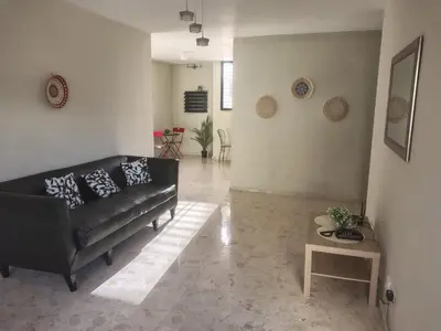 a living room with a black couch and a table at La Guarida de Mela in Santo Domingo