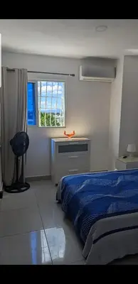 a bedroom with a bed and a desk and a window at Mitaly Apartamentos 111 in Santo Domingo