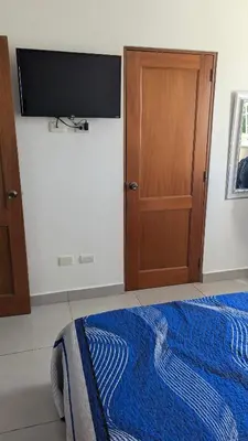 a bedroom with a bed and a flat screen tv at Mitaly Apartamentos 111 in Santo Domingo