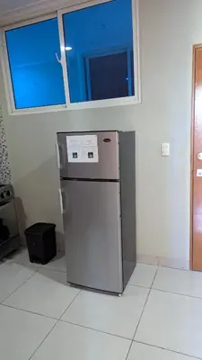 a small refrigerator in a room with a window at Mitaly Apartamentos 111 in Santo Domingo
