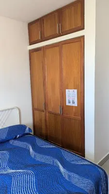 a bedroom with a bed and a wooden cabinet at Mitaly Apartamentos 111 in Santo Domingo
