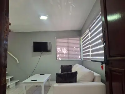a living room with a white couch and a table at beautiful Penthouse in the middle of Sosua walking distance to everything in Sosúa