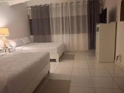 a hotel room with two beds and a television at beautiful Penthouse in the middle of Sosua walking distance to everything in Sosúa