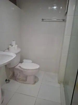 a white bathroom with a toilet and a shower at beautiful Penthouse in the middle of Sosua walking distance to everything in Sosúa