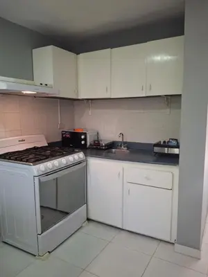 a kitchen with a stove and white cabinets at beautiful Penthouse in the middle of Sosua walking distance to everything in Sosúa