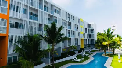 an apartment building with a swimming pool and palm trees at Apartment in Punta Cana