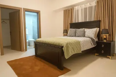 a bedroom with a large bed and a bathroom at Elegant Downtown Stay Santo Domingo in Santo Domingo