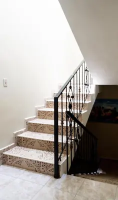 a staircase in a house with a black railing at 4BR Villa Newly Renovated-5 min to Playa Dorada H1 in San Felipe de Puerto Plata