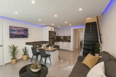 a kitchen and living room with a couch and a table at Stylish Sosua 2 BR apartment near everything in Sosúa