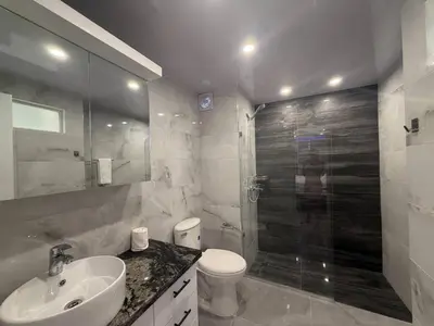 a bathroom with a toilet and a sink and a shower at Stylish Sosua 2 BR apartment near everything in Sosúa