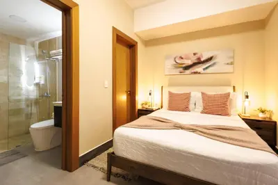 a bedroom with a bed and a bathroom with a shower at Upscale City Center Condo, Pool, Gym in Santo Domingo