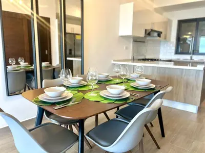 a wooden table with chairs and wine glasses on it at Chic 2BR Apt 1km from Playa Bonita in Las Terrenas