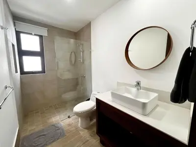a bathroom with a sink and a toilet and a mirror at Chic 2BR Apt 1km from Playa Bonita in Las Terrenas