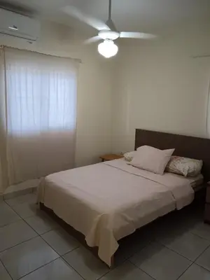 a bedroom with a bed with a ceiling fan at Jolie maison in La Romana